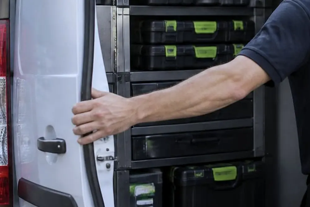 Open door of a service van showing racks of parts cases